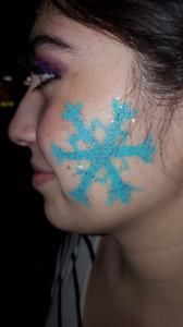 A woman has a snowflake painted on her face.