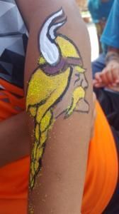 A person has a viking head painted on their arm.