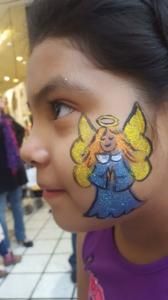 A little girl has an angel painted on her face.