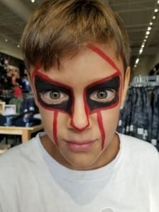 A young boy with his face painted black and red