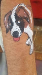 A black and white dog is painted on a wooden skateboard.