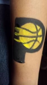 A person has a tattoo of a basketball on their arm