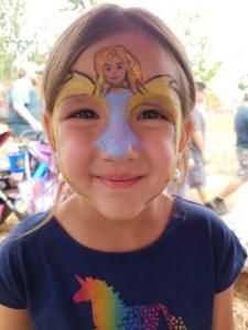 A little girl with a face paint of a fairy on her face