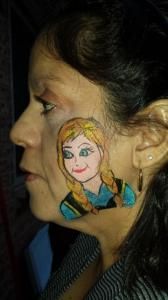 A woman has a drawing of anna on her face.