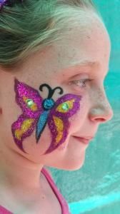 A little girl with a butterfly painted on her face.