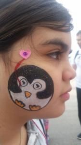 A girl with a penguin painted on her face.
