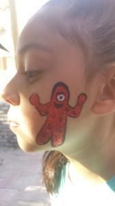A girl with a red octopus painted on her face.