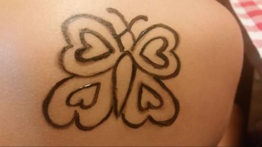 A person has a butterfly tattoo on their back