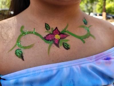A woman has a flower painted on her chest