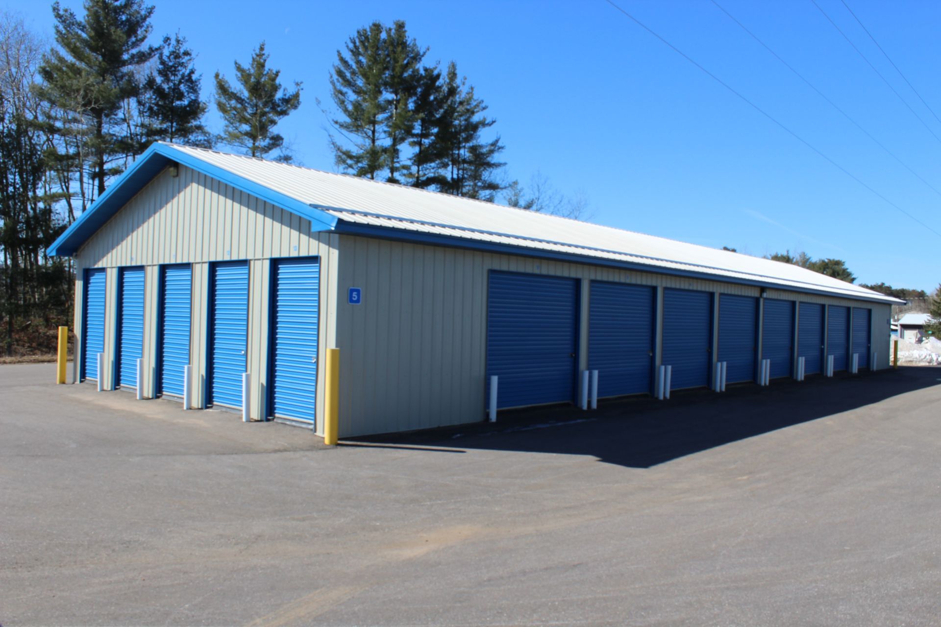 A storage building with blue doors and a white roof
