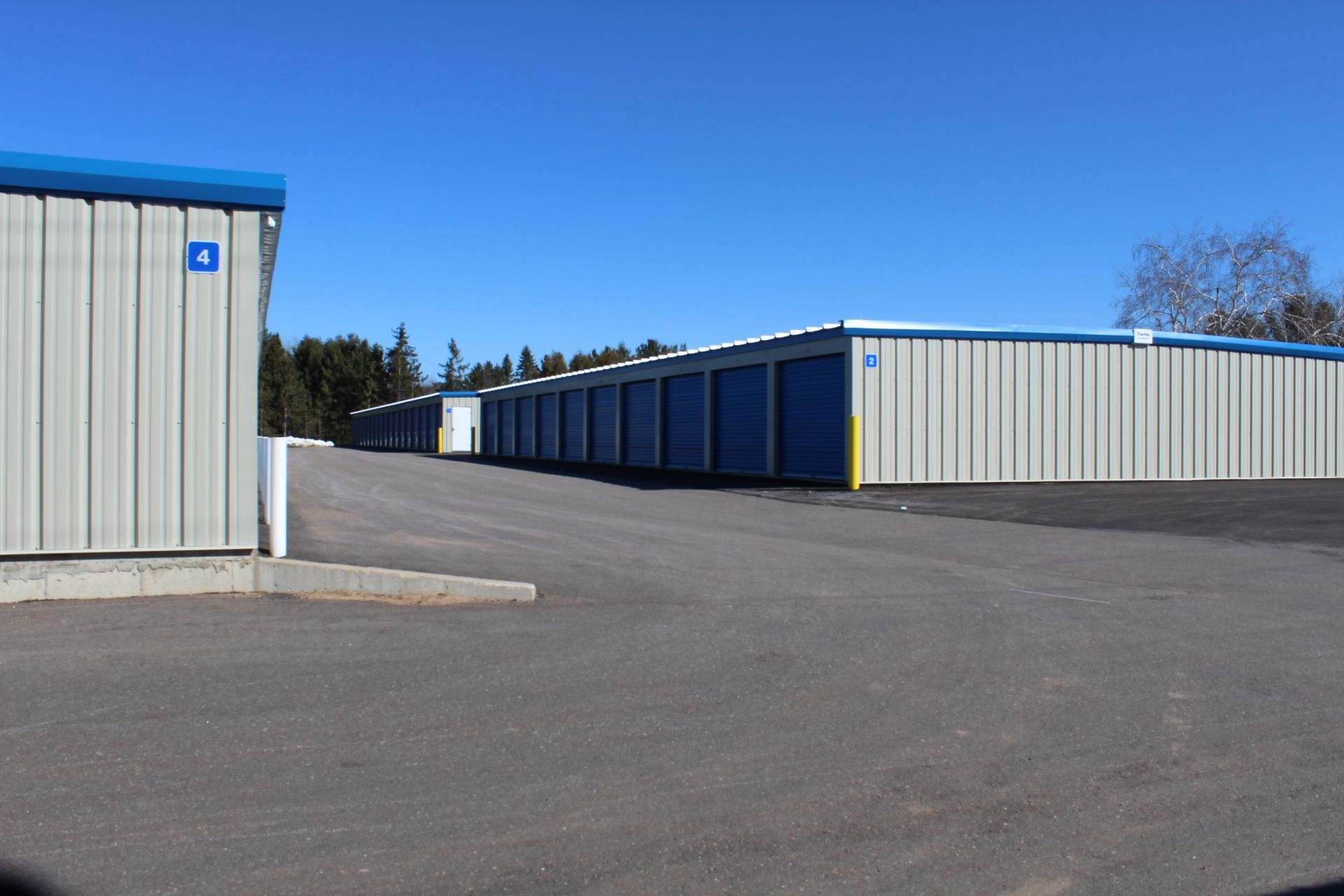 A row of storage units are lined up in a parking lot