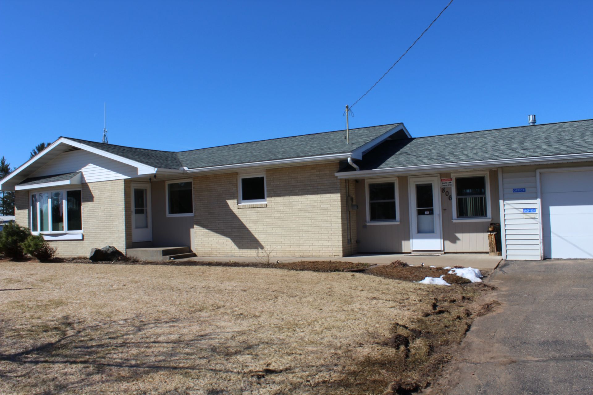 A house with a gray roof and a white garage door