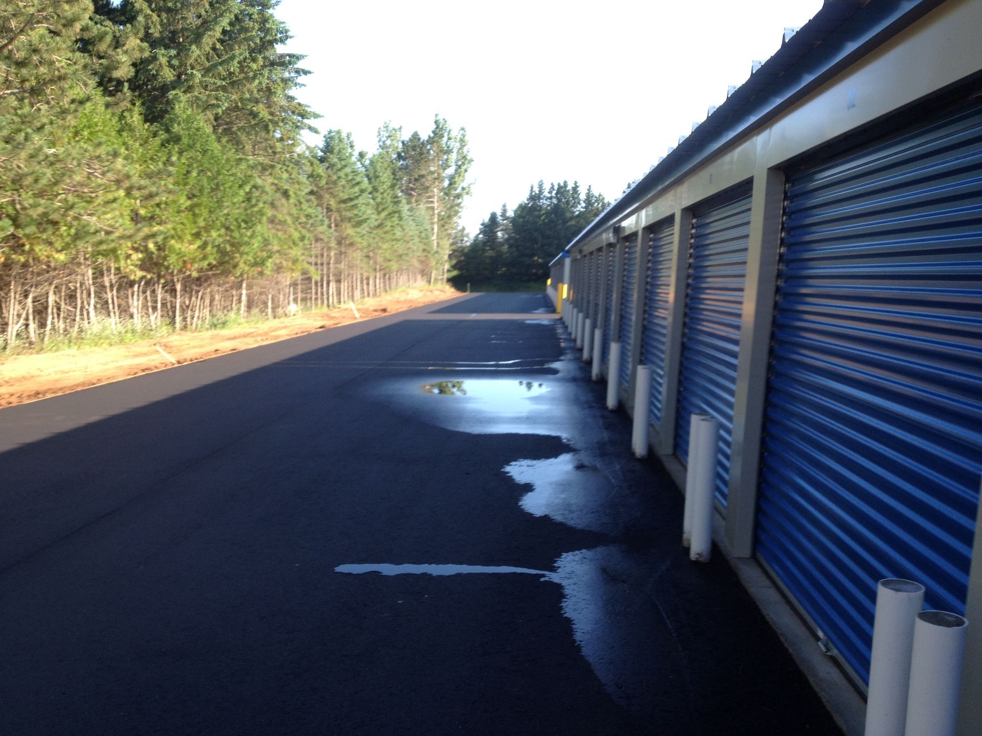 A row of blue storage units on the side of a road