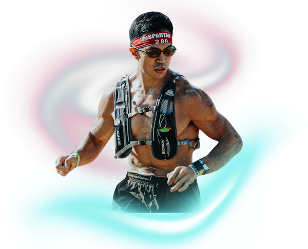 A shirtless, muscular runner wearing sunglasses, a red headband, and a black running vest, captured in motion.