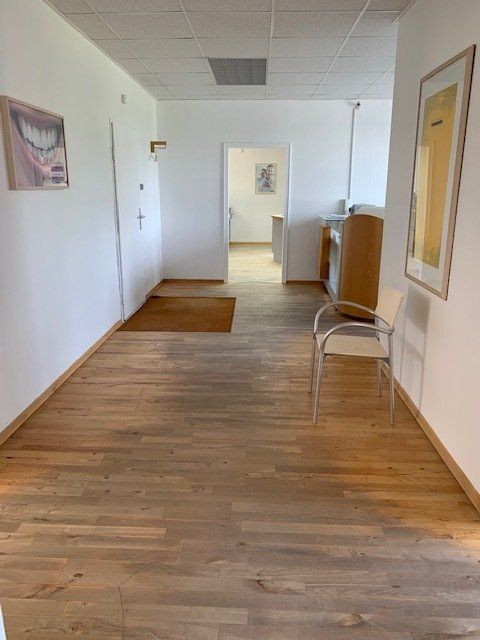 Ein Flur mit einem Stuhl und einem Bild an der Wand