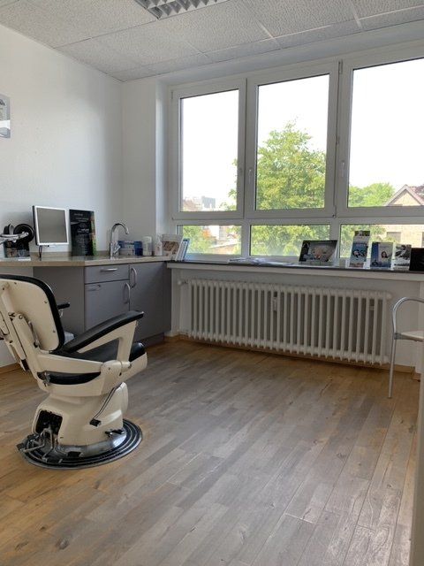 Eine Zahnarztpraxis mit einem Stuhl und einem Fenster