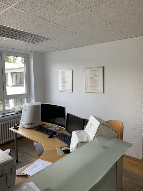 Ein Schreibtisch mit zwei Monitoren und einem Drucker darauf