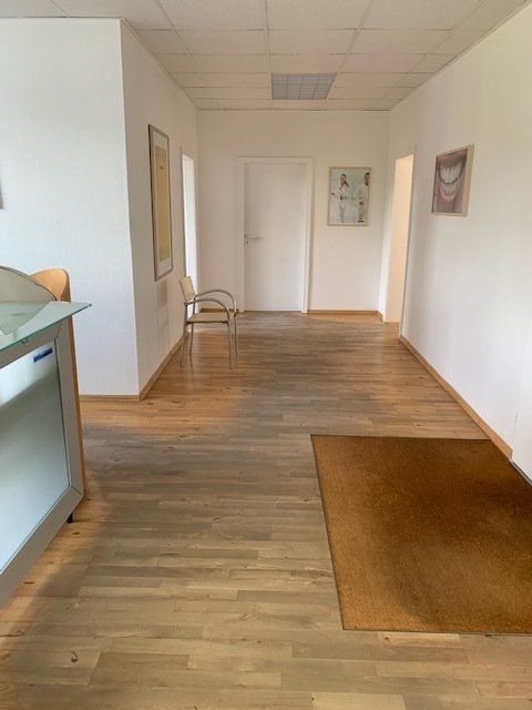 Ein Flur mit Holzboden und weißen Wänden