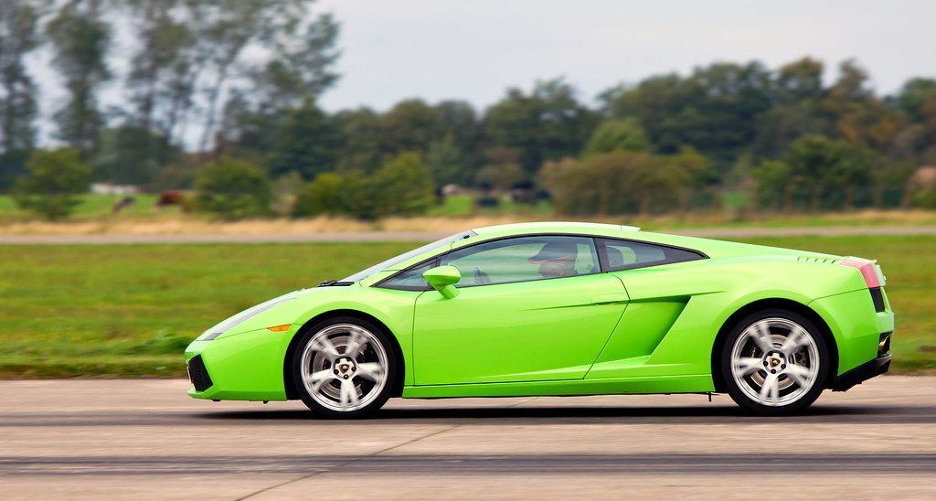 Green Lamborghini sports car on a racetrack.