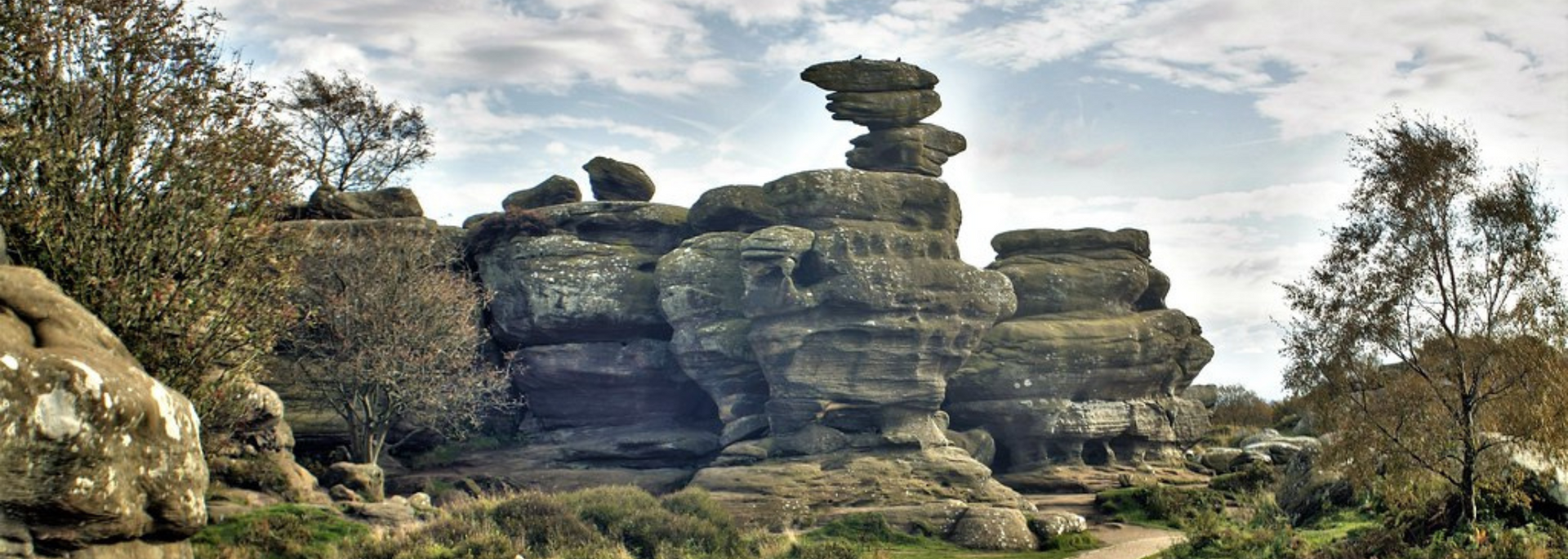 Unique rock formations in a natural landscape, under a cloudy sky.