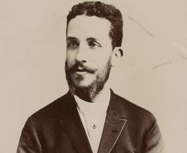 Portrait of a man in a suit, with a beard and mustache, looking towards the viewer.