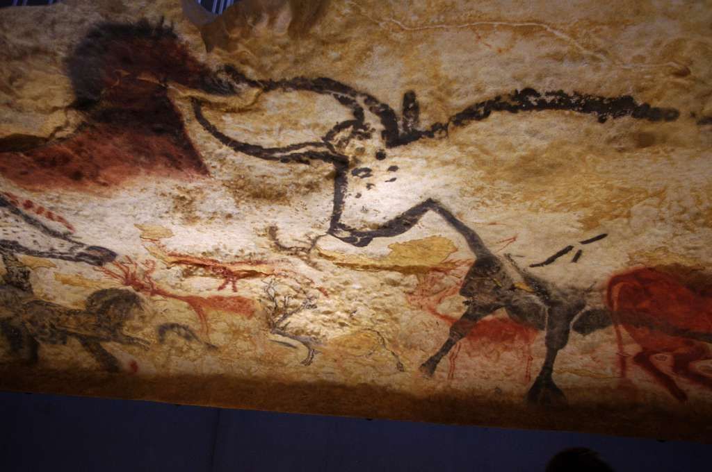 Cave painting of bison and other animals in brown, red, and black.