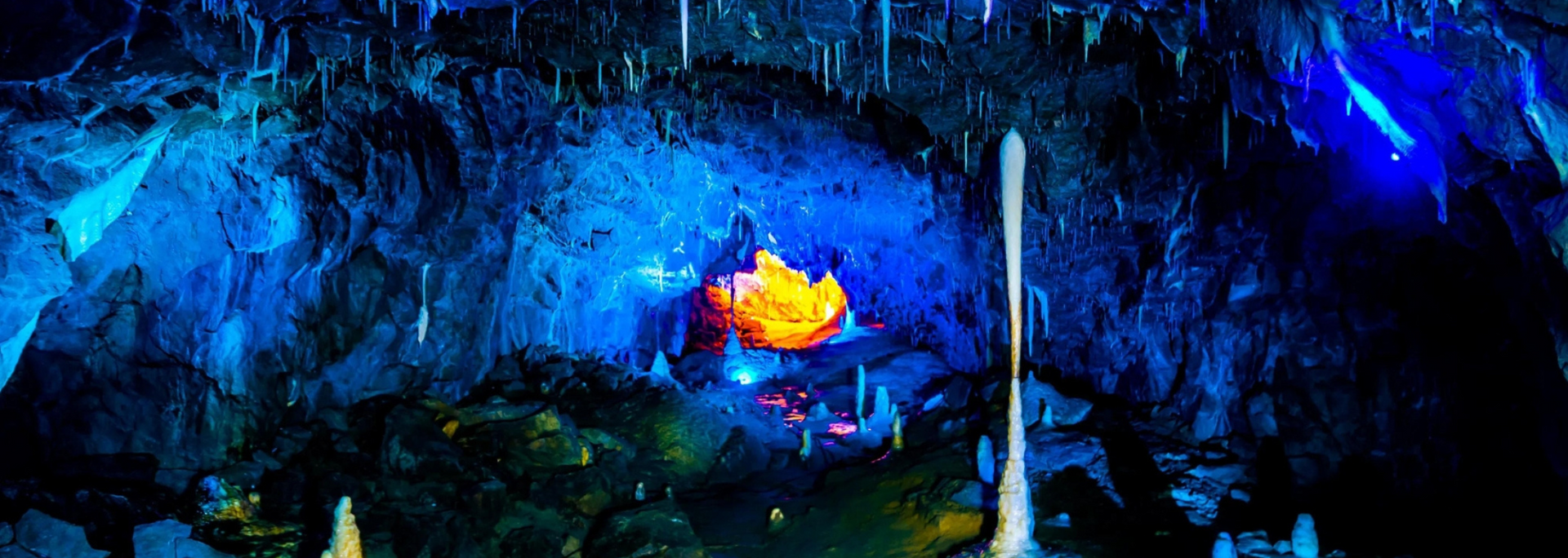 A blue-lit cave with a glowing orange center, possibly an underwater scene.