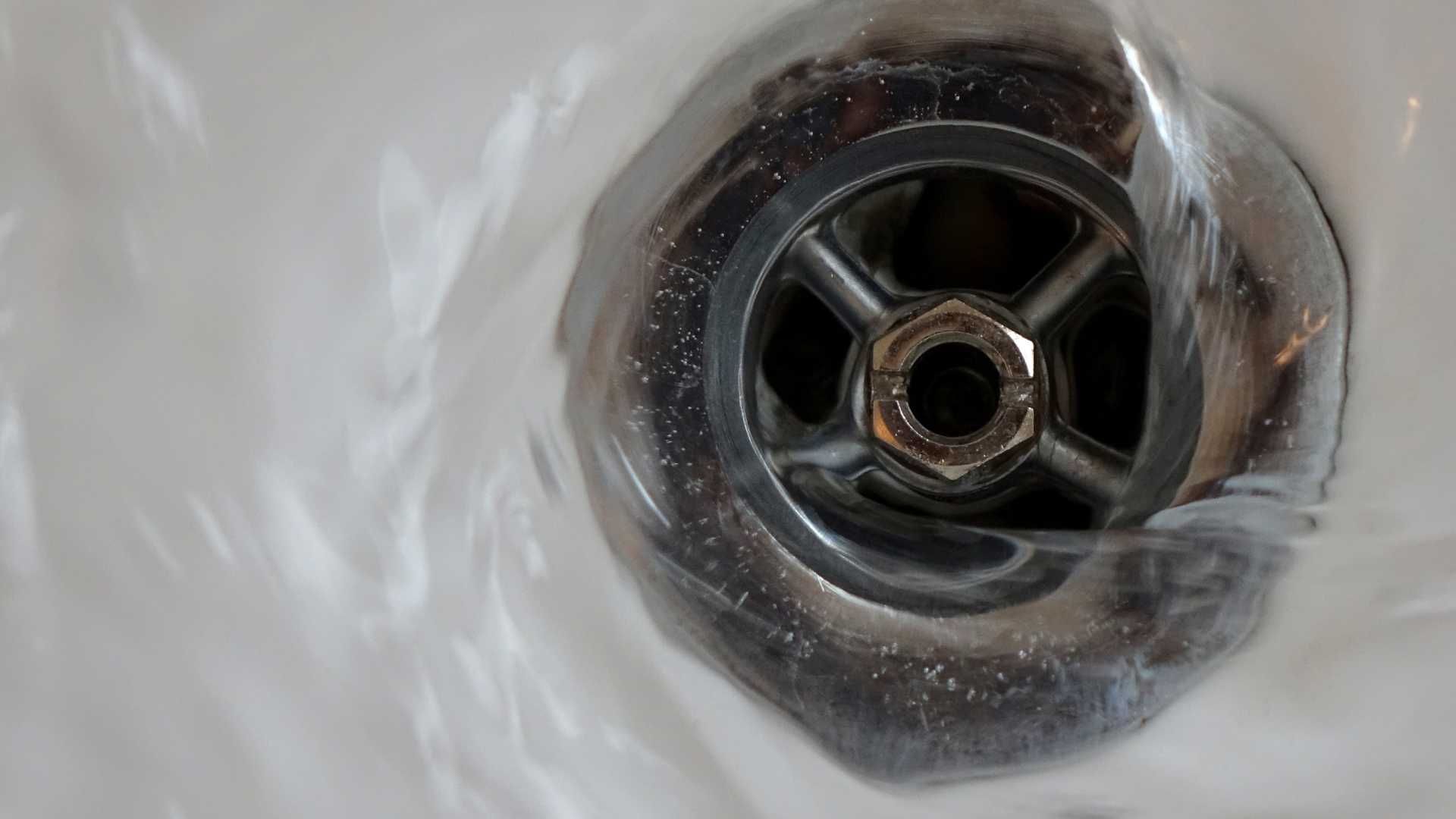 water is running down a drain in a bathroom sink .