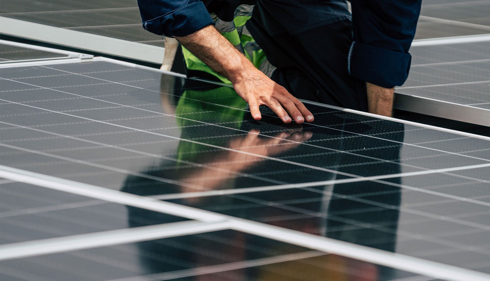 Person installing solar panels on a roof.