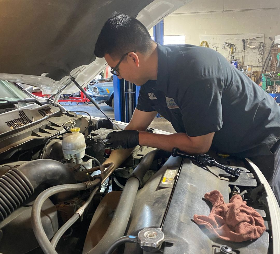 A mechanic working on a vehicle at our repair shop | Alpine Automotive Service