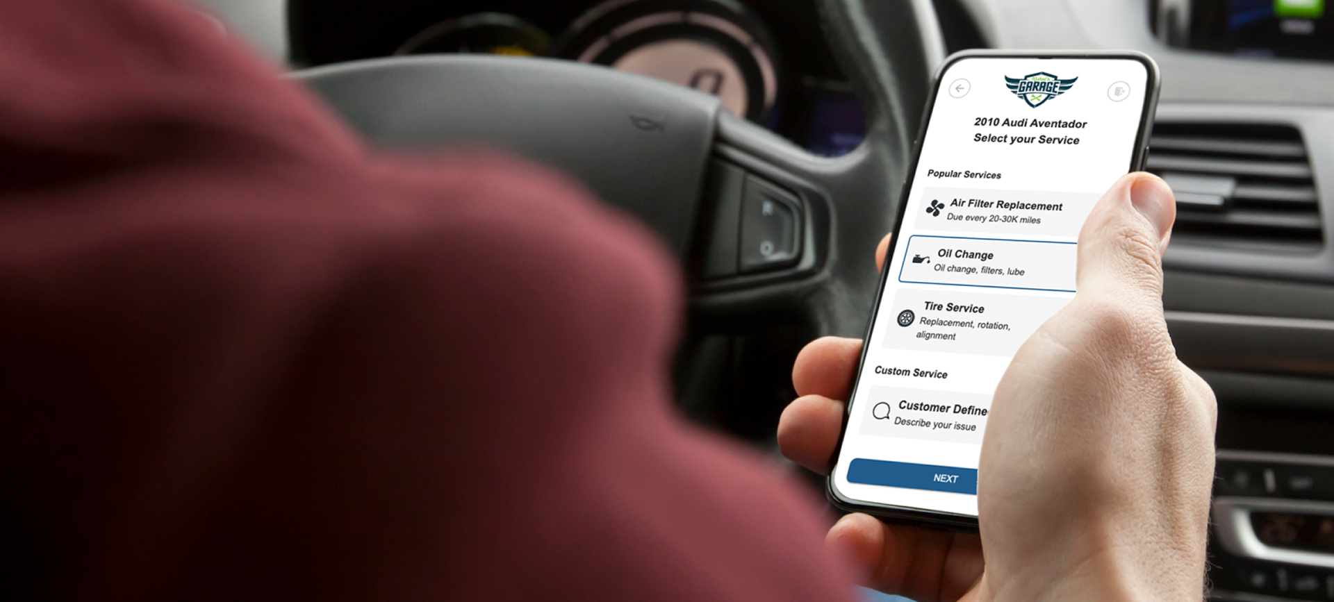 A person is holding a cell phone in their hand while driving a car. | Alpine Automotive Service