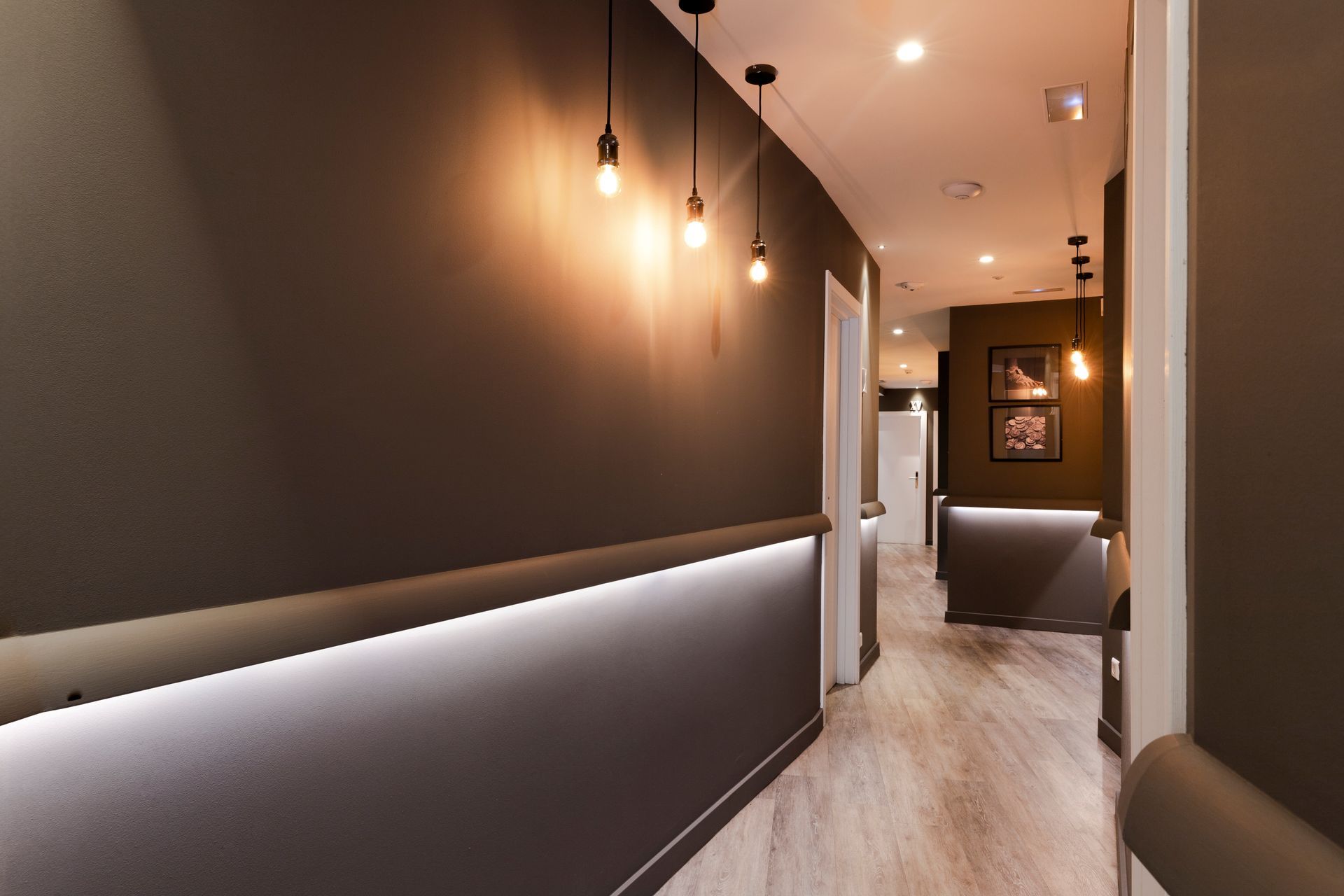 A long hallway in a building with lights on the wall