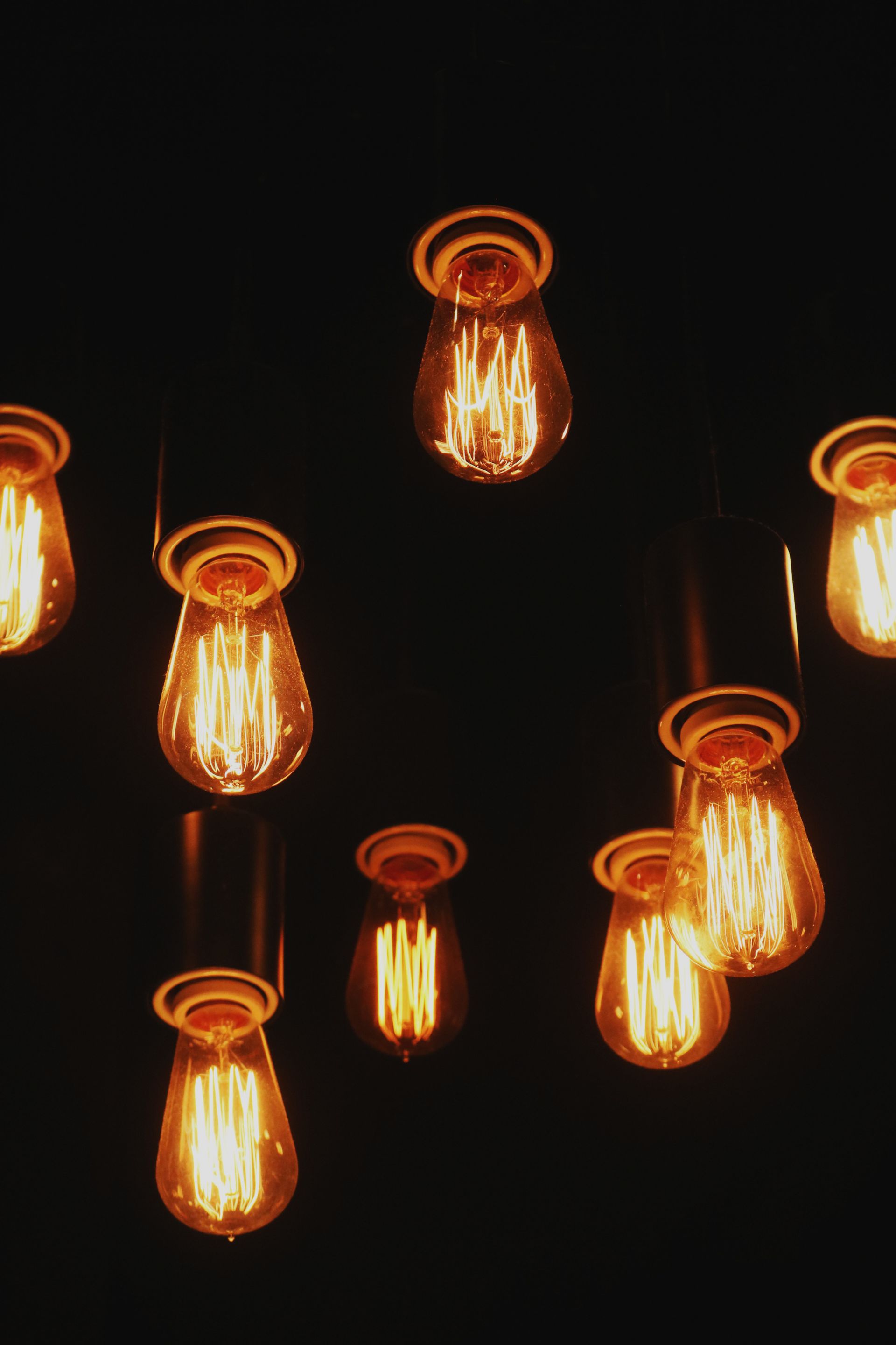 A bunch of light bulbs hanging from the ceiling in a dark room.