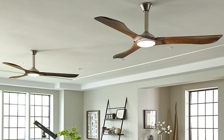 Two ceiling fans are hanging from the ceiling of a living room.