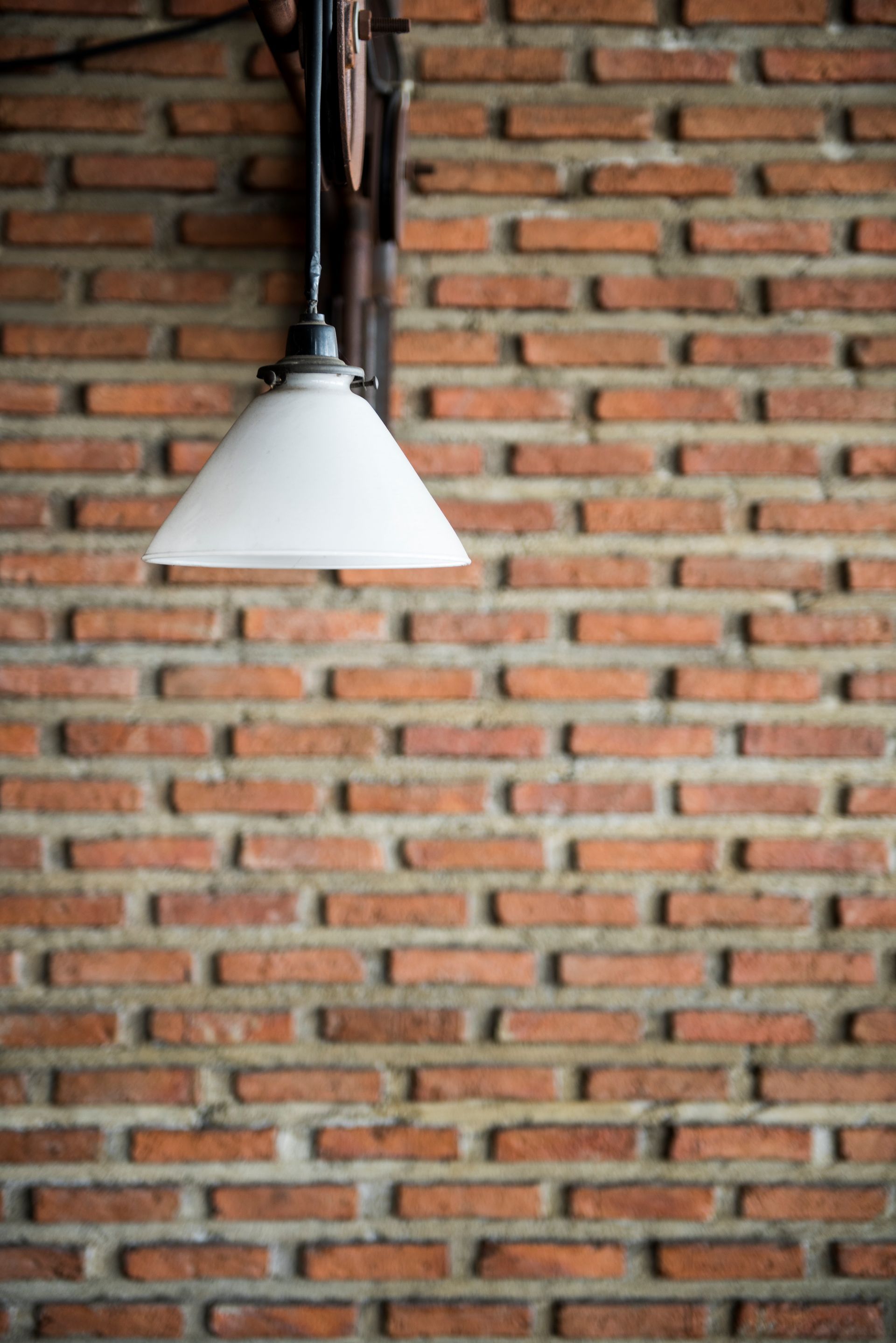 A brick wall with a lamp hanging from it.