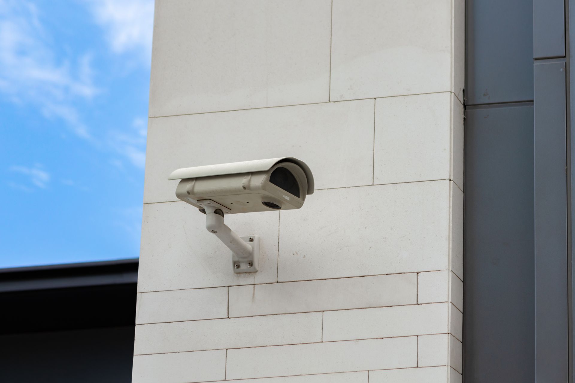 A security camera is mounted on the side of a building.