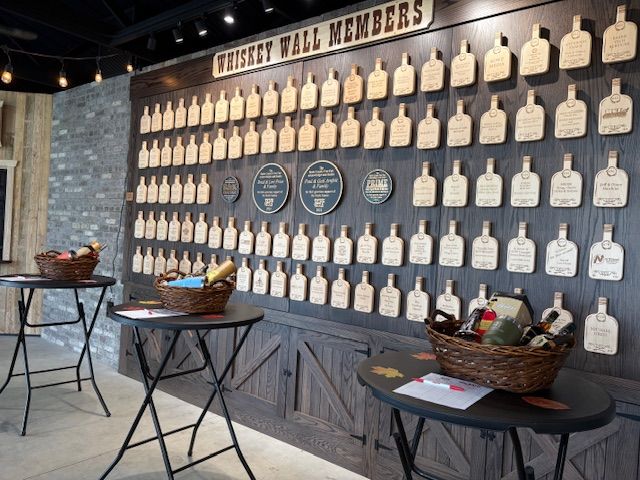 A wall of commemorative wooden bottle tags titled 