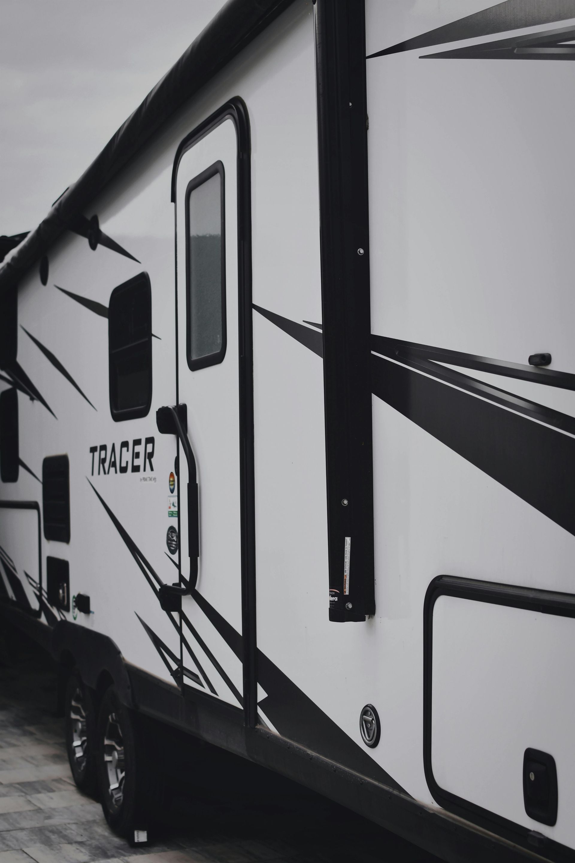Outdoor flea market with shoppers browsing various items under tents.