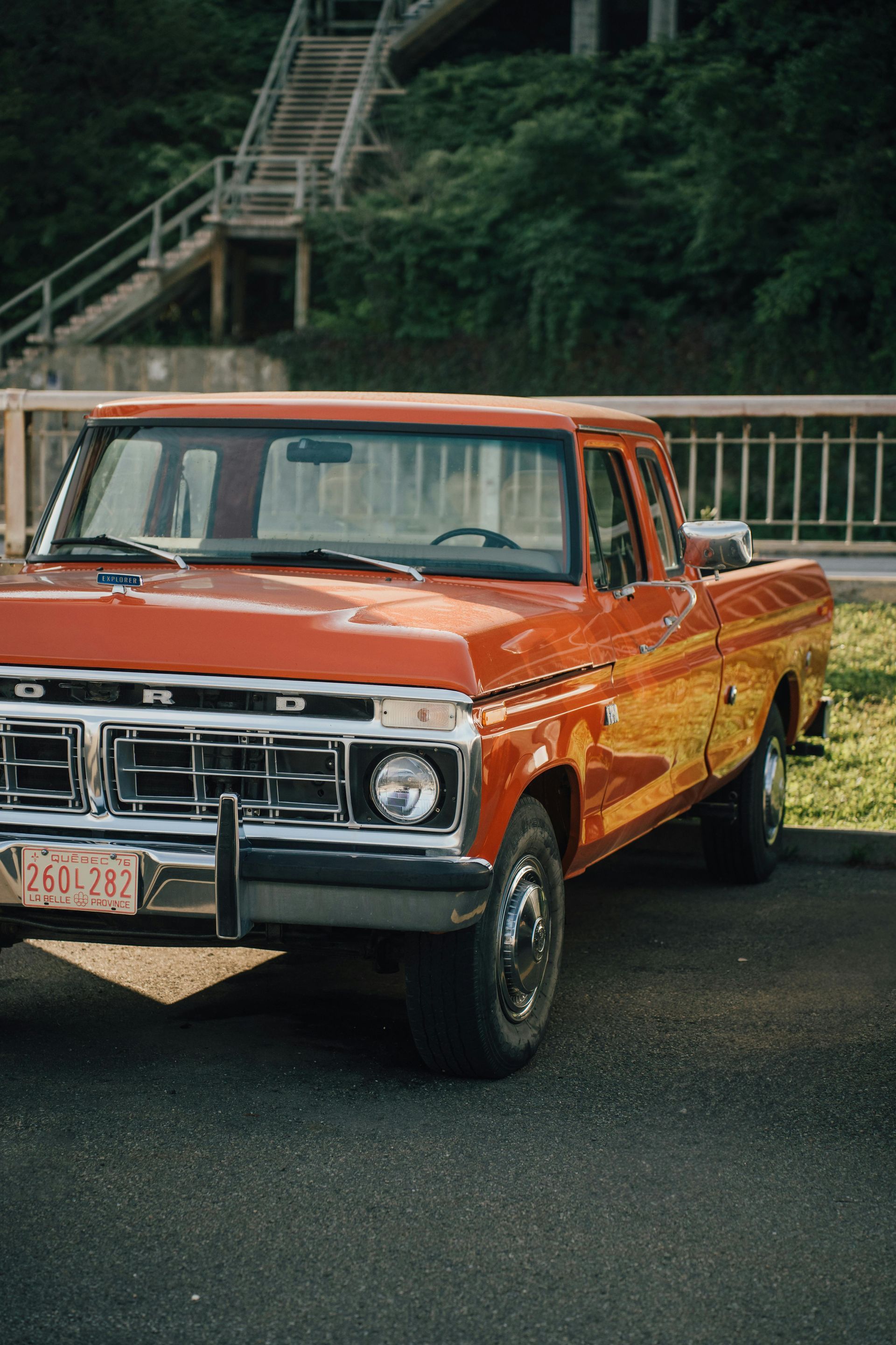 Orange vintage Ford pickup truck parked outdoors.