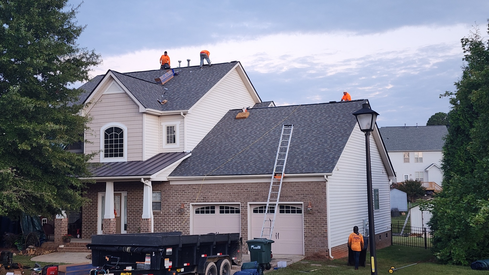 A group of people are working on the roof of a house