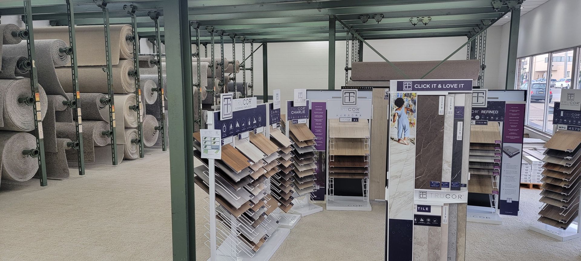 Interior of a flooring store with rolls of carpet on racks and displays of flooring samples. Interior of a flooring store with rolls of carpet on racks and displays of flooring samples.