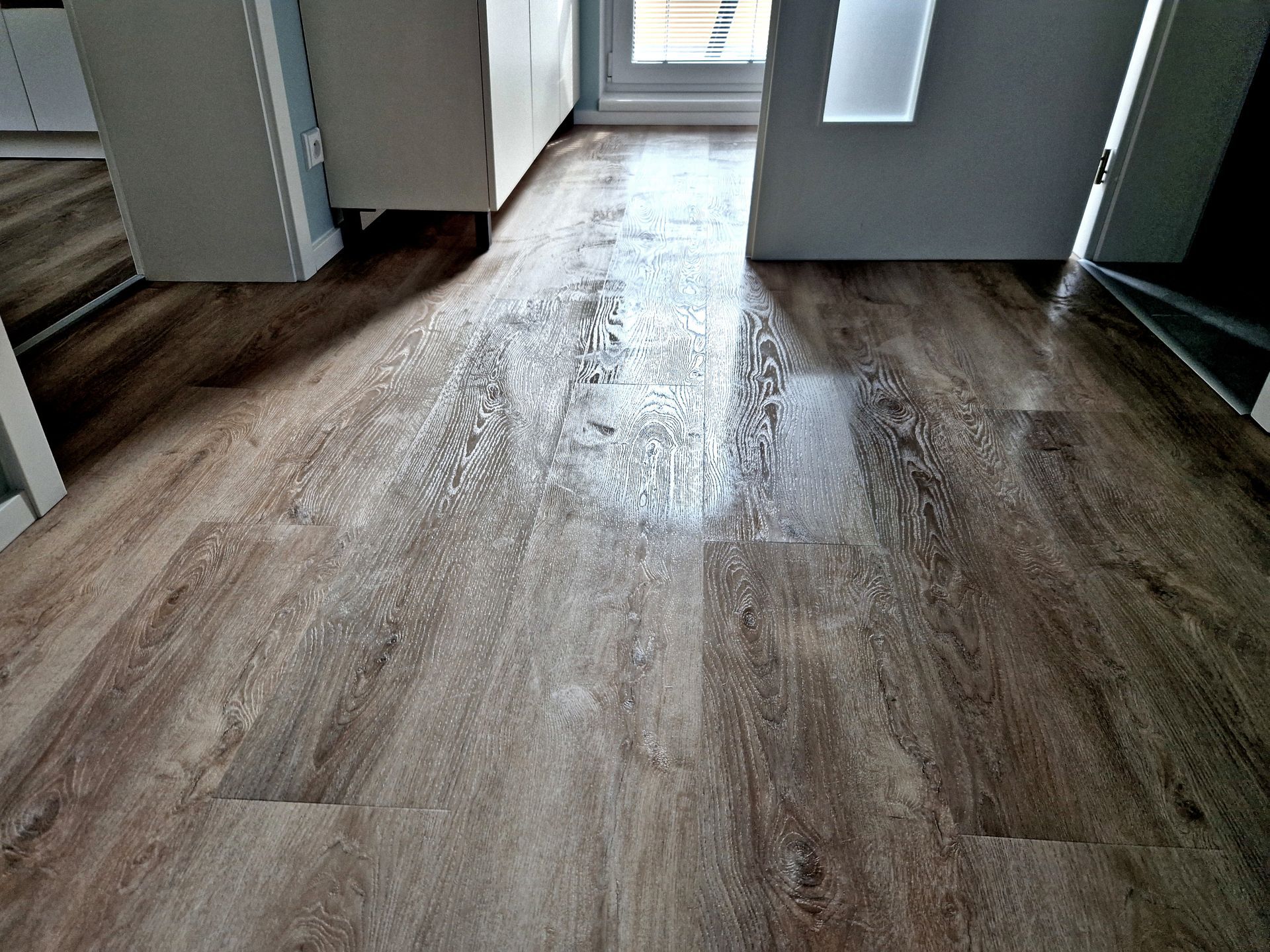 Brown vinyl flooring, measuring tape, and utility knife on a wooden surface. Brown vinyl flooring, measuring tape, and utility knife on a wooden surface.