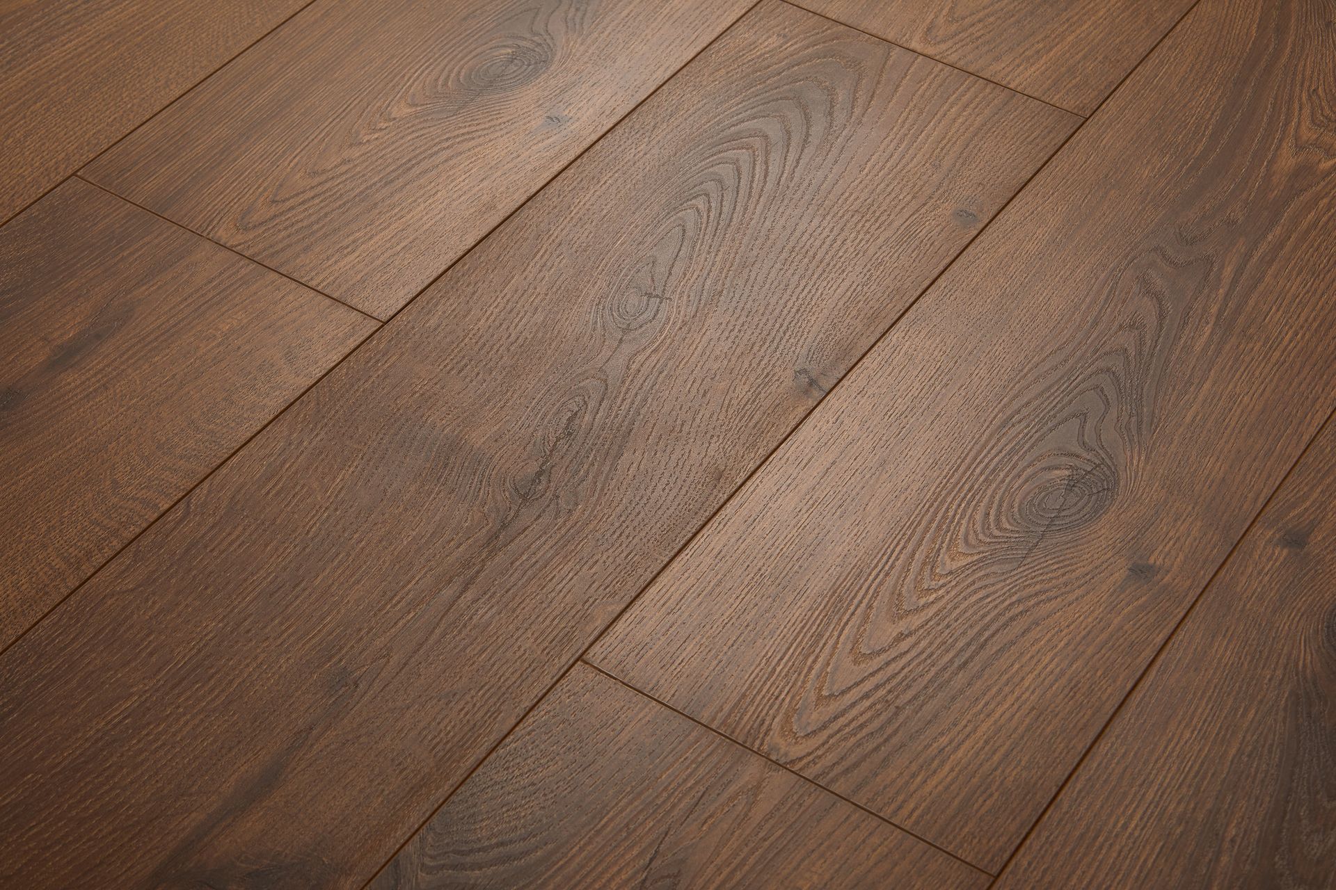 Person installing wood-look vinyl flooring, kneeling. They are bending the flooring over the floor with a troweled adhesive. Person installing wood-look vinyl flooring, kneeling. They are bending the flooring over the floor with a troweled adhesive.