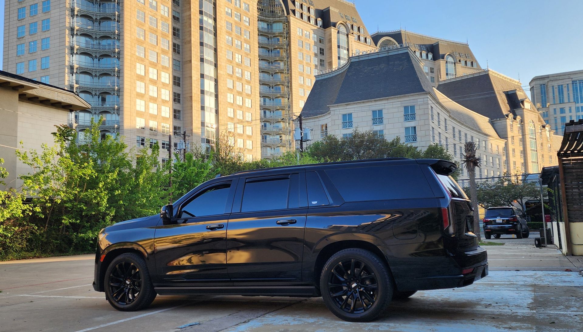 A black suv is parked in a parking lot in front of a building.
