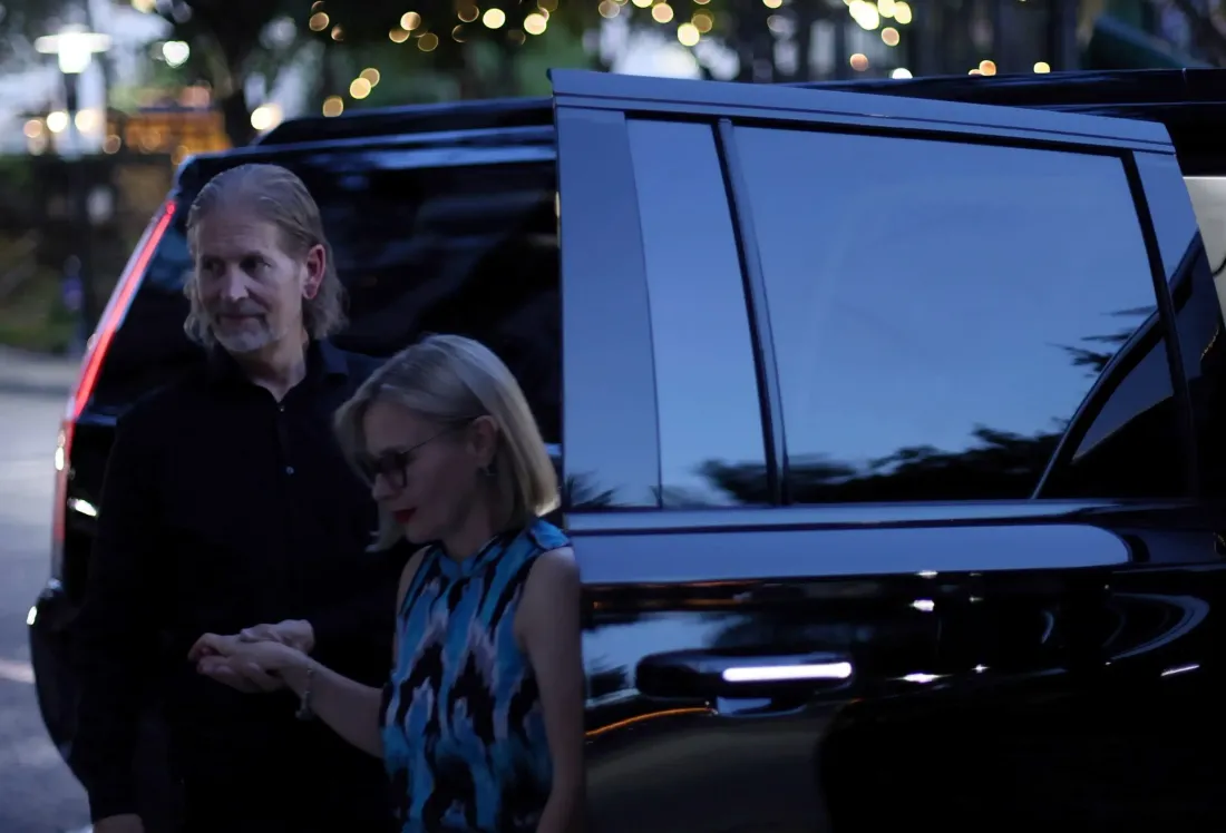 A man and a woman are getting out of a car.
