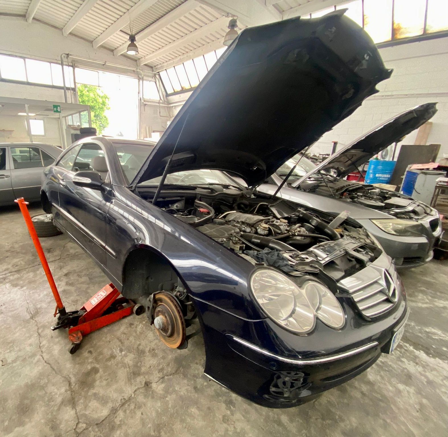 Un'auto con il cofano alzato è parcheggiata in un garage