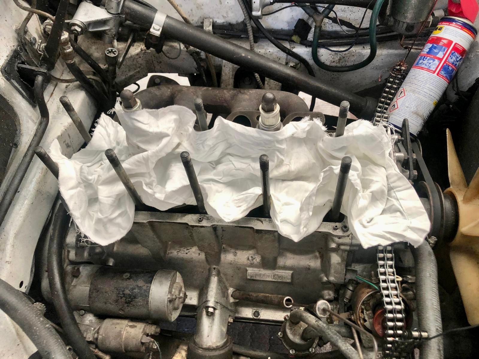 Un primo piano del motore di un'auto con un pezzo di carta sopra.