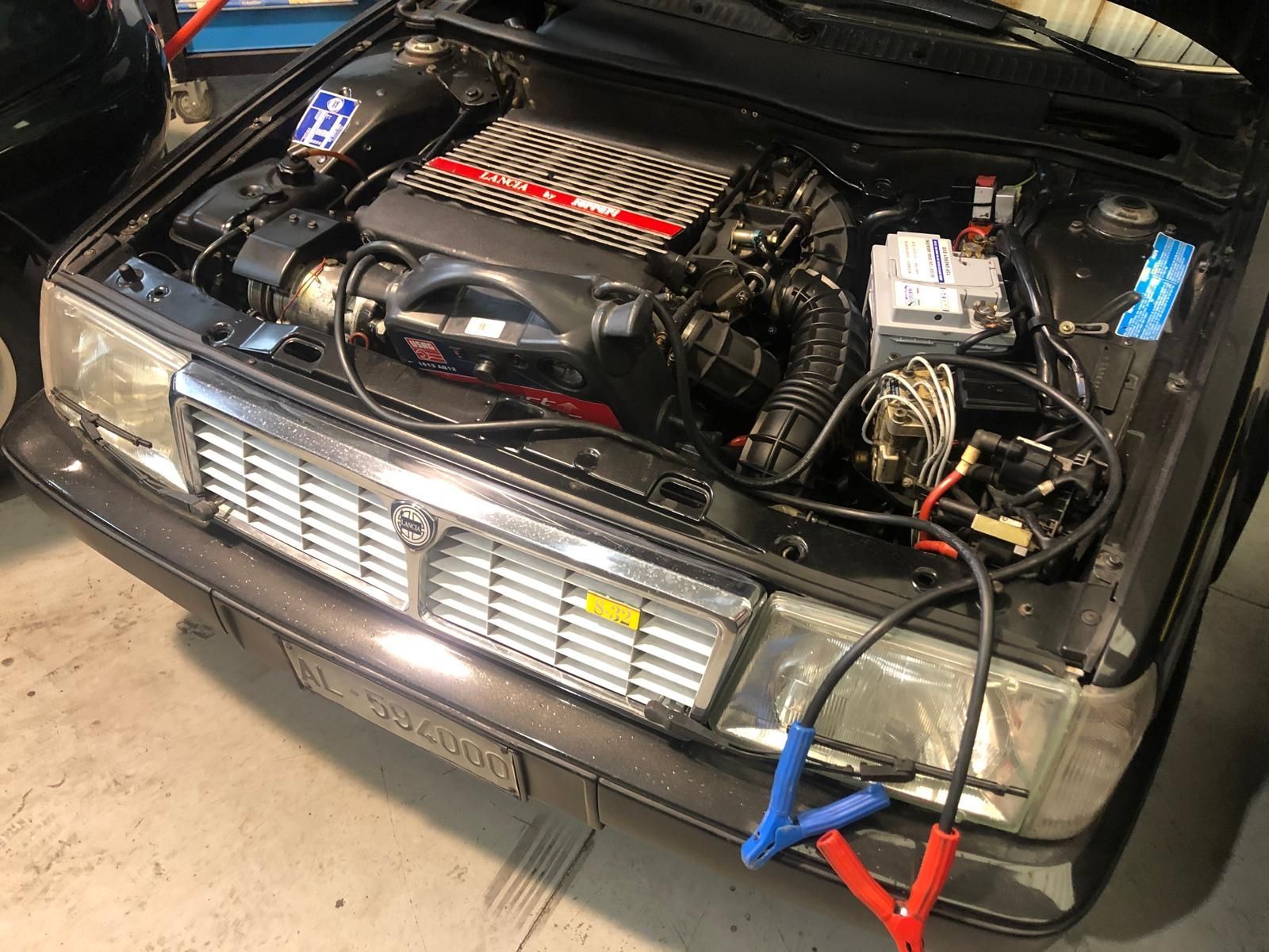 Il motore di un'auto viene caricato con cavi di avviamento.