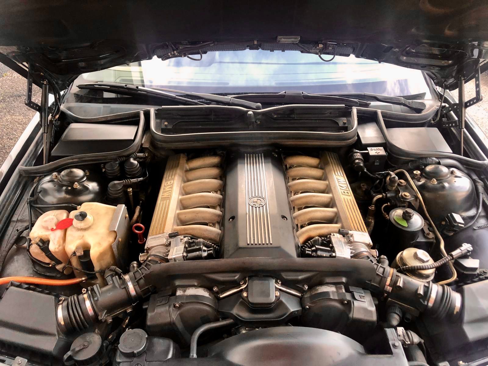 Un primo piano del motore di un'auto con il cofano aperto