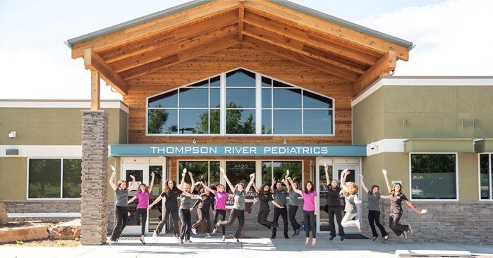 Thompson River Pediatrics staff jumping joyfully in front of their building.